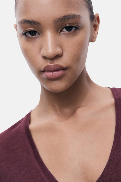 T-shirt bordeaux à manches courtes de MANGO, sur une femme à la peau lisse.