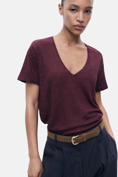 Bordeaux T-shirt met korte mouwen van MANGO, gedragen met een bruine riem en een gestreepte broek.