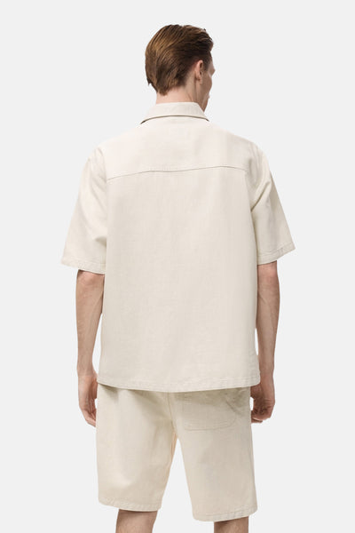Ecru spijkerblouse van MANGO, achterkant, met pas en relaxte pasvorm.