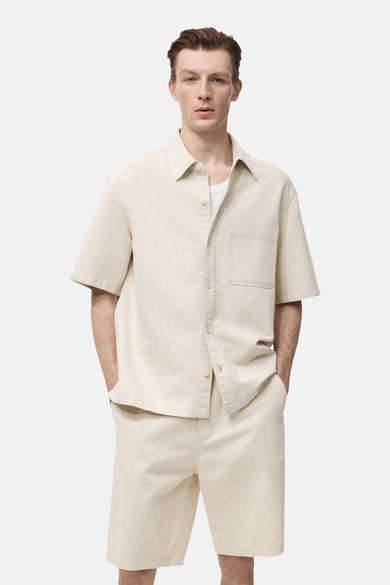 Ecru spijkerblouse met korte mouwen en borstzak van MANGO.