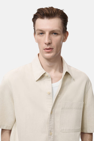 Chemise en jean écrue de MANGO, avec poche poitrine et coupe décontractée.