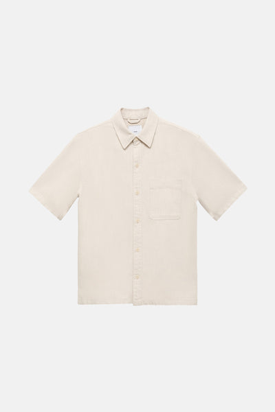 Chemise en jean écru de MANGO, à manches courtes, avec une poche poitrine plaquée.