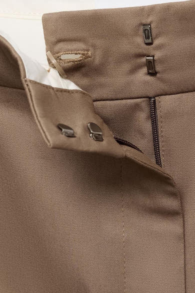 Pantalon beige by MANGO, détail de la fermeture avec agrafes et bouton, texture côtelée visible.