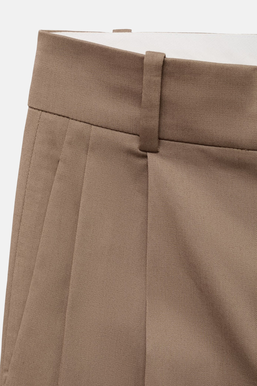 Pantalon beige à plis de MANGO, montrant la ceinture et le devant du pantalon.