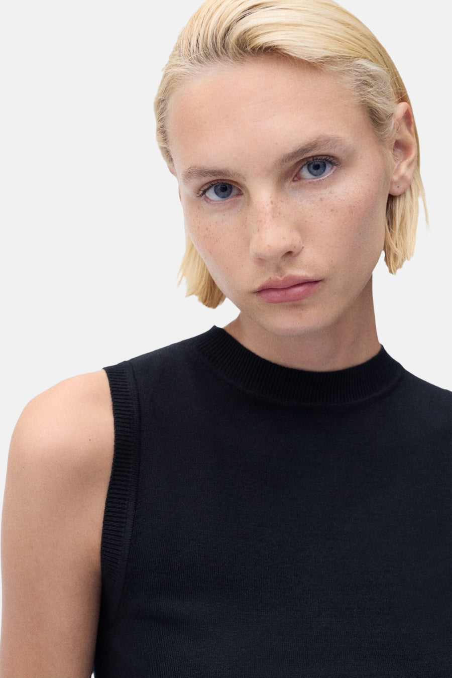 Blauw mouwloos topje van MANGO, gedragen door een model met kort blond haar.