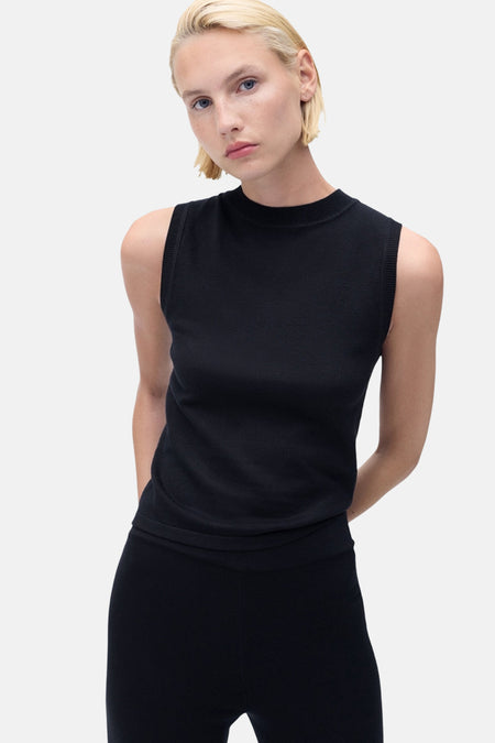 Blauw mouwloos topje van MANGO, gedragen met een effen zwarte legging.