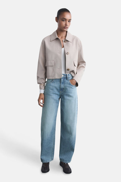 Lichtblauwe jeans van MANGO, gedragen met een beige jas en zwarte schoenen.