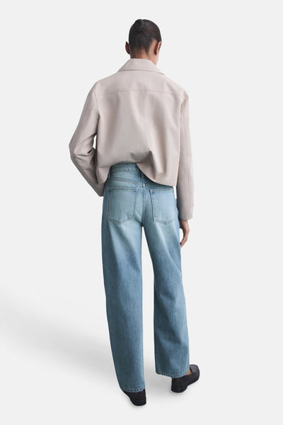 Lichtblauwe denim jeans van MANGO, losse pasvorm, achterkant, gedragen met een beige jas.