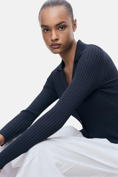 Blauwe geribbelde cardigan van MANGO, gedragen door een model op een witte achtergrond.