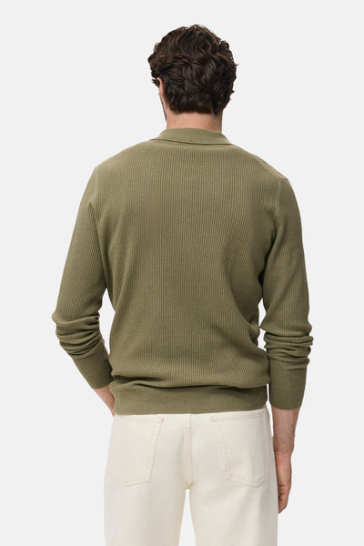 Kaki ronde hals trui van MANGO, in geribde gebreide stof, gedragen met een witte broek, achterzicht.