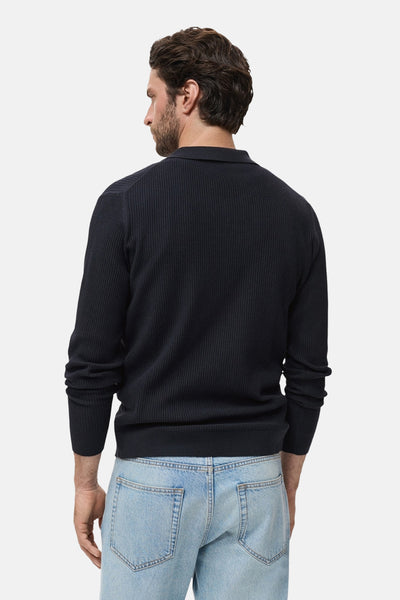 Blauwe trui met ronde hals van MANGO, in geribbelde breinaalden, gedragen met een lichtblauwe jeans, achterzicht.