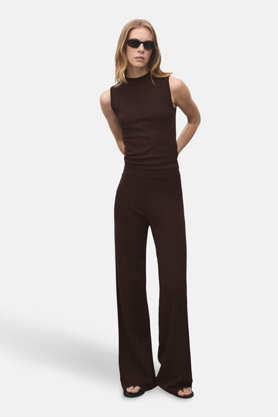 Pantalon marron de MANGO, ample avec des jambes larges, porté avec un haut assorti et des lunettes de soleil.