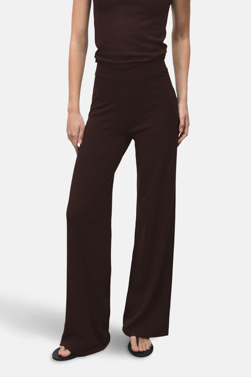 Pantalon large brun de MANGO, porté avec un haut assorti et des sandales noires.