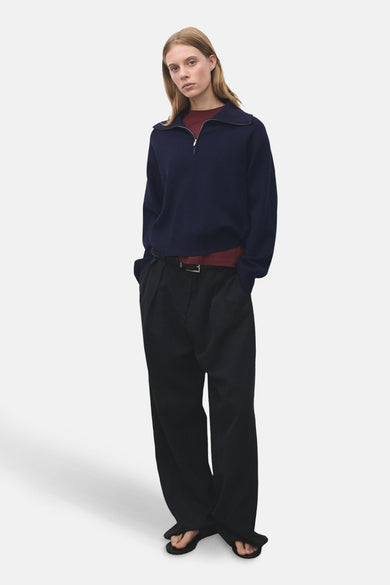 Blauwe coltrui van MANGO, gedragen met een bordeauxrood T-shirt en een zwarte broek met hoge taille.