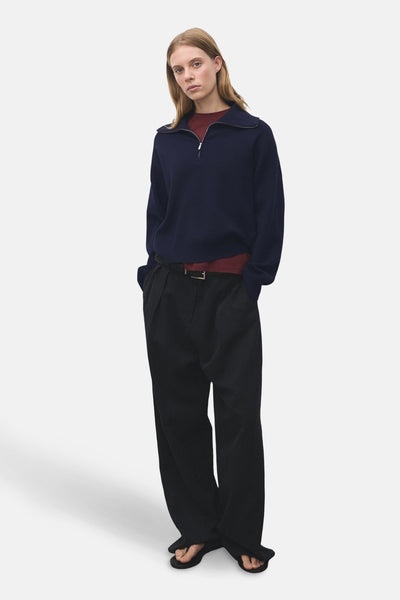Blauwe coltrui van MANGO, gedragen met een bordeauxrood T-shirt en een zwarte broek met hoge taille.