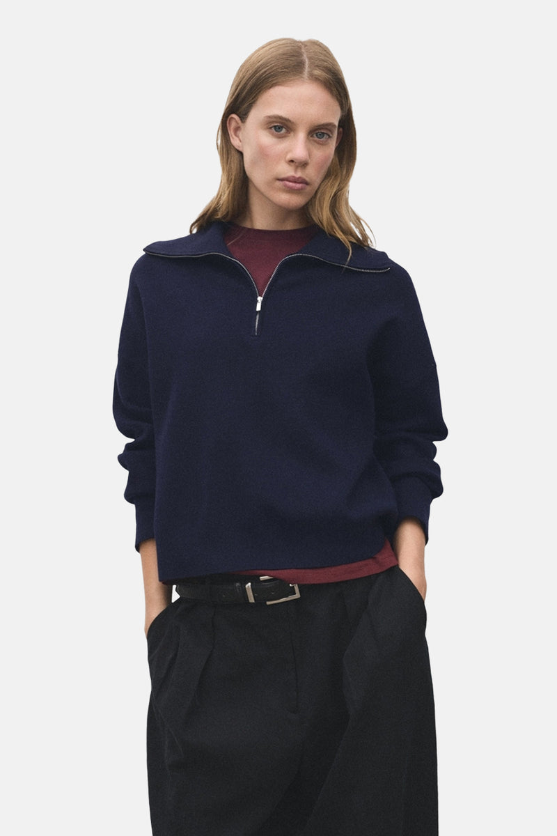 Blauwe coltrui van MANGO, gedragen met een zwarte broek met riem.