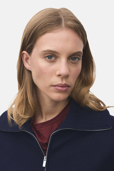 Blauwe coltrui van MANGO met ritssluiting en zichtbaar bordeauxrood T-shirt.