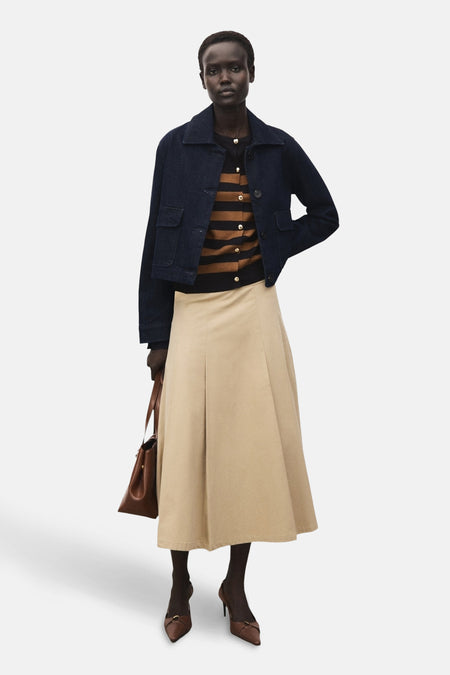 Multikleurige cardigan van MANGO, gedragen met een blauwe jas en een beige plooirok.