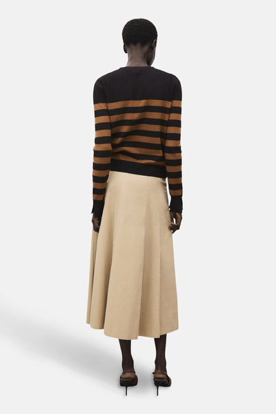 Cardigan rayé en maille de MANGO, porté avec une jupe évasée beige et des chaussures à talons marron, vue de dos.