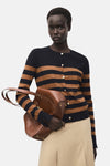 Zwart-bruin gestreepte cardigan van MANGO, gedragen met een beige broek en een bruine leren handtas.