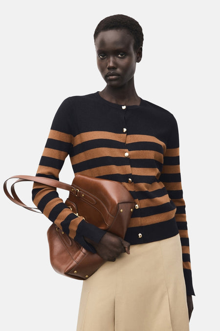 Zwart-bruin gestreepte cardigan van MANGO, gedragen met een beige broek en een bruine leren handtas.
