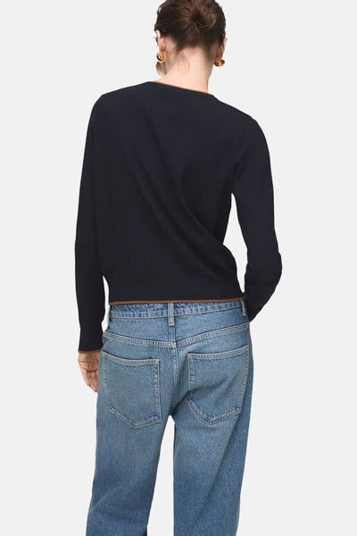 Cardigan bleu foncé de MANGO, porté avec un jean bleu taille haute, vue de dos.
