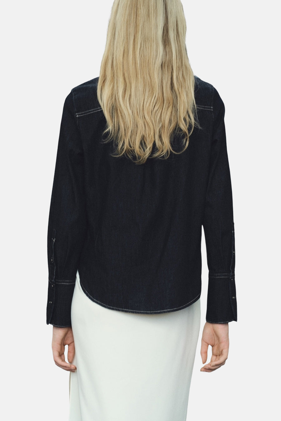 Chemise en denim bleu foncé à manches longues de MANGO, avec détails de surpiqûres contrastantes.
