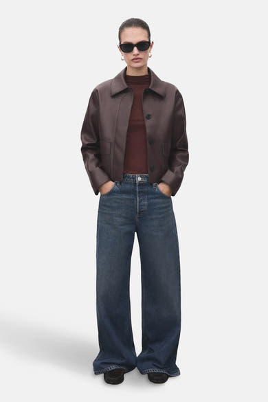 T-shirt à manches longues brun de MANGO, porté avec une veste en cuir et un jean taille haute.