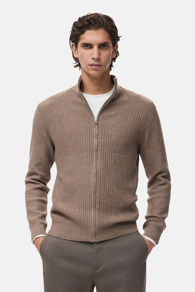 Gilet brun en maille côtelée de MANGO, porté sur un t-shirt blanc, avec un pantalon assorti.