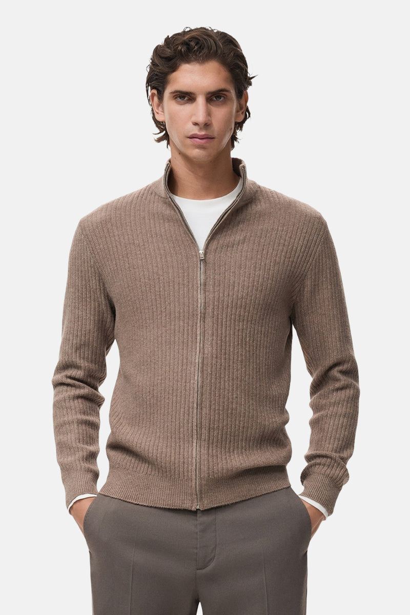 Gilet brun en maille côtelée de MANGO, porté sur un t-shirt blanc, avec un pantalon assorti.