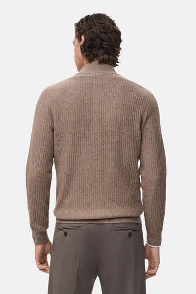 Gilet marron en maille côtelée de MANGO, vue de dos avec un pantalon marron assorti.