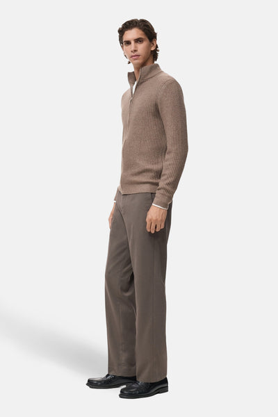 Gilet marron par MANGO, fermeture éclair sur le devant, porté avec un pantalon et des chaussures noires.