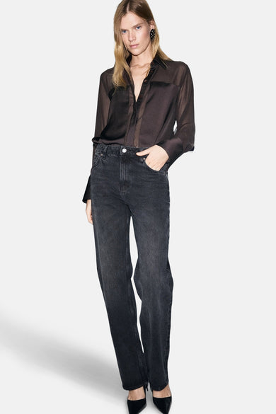 Chemise brune à manches longues de MANGO, portée avec un jean taille haute et des escarpins noirs.