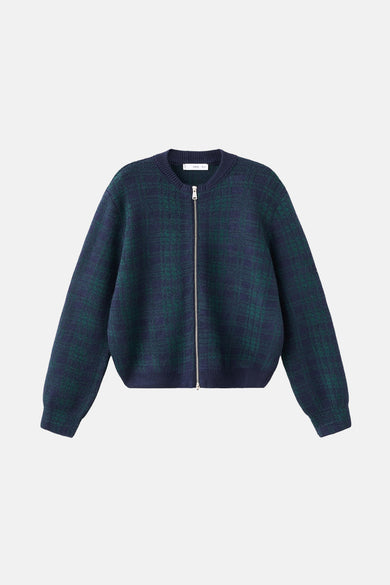 Multikleurend gilet van MANGO, gedragen met een donkere jeans, een suède tas en een ronde zonnebril.