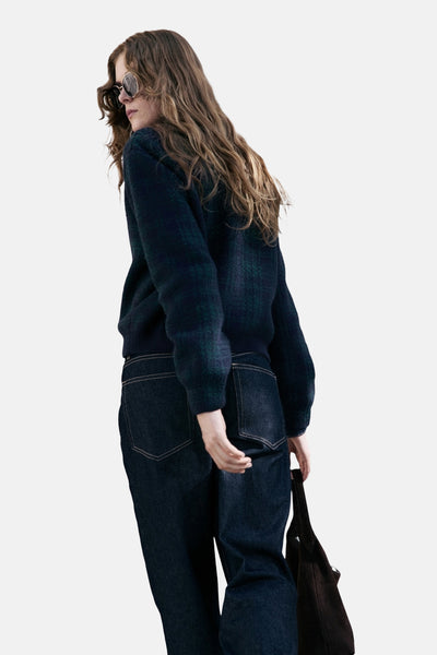 Gilet multicolore de MANGO, porté avec un jean bleu foncé et des lunettes de soleil rondes, vue de dos.