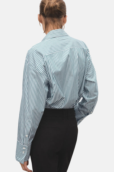 Chemise à manches longues verte à rayures, de MANGO, vue de dos, portée avec un pantalon noir uni.
