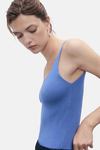 Blauwe tanktop van geribbelde stof van MANGO, gedragen met zilveren oorbellen.
