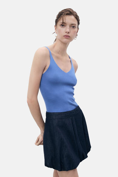 Blauwe tanktop van MANGO, in geribbelde breiwerk met dunne bandjes, gedragen met een uitlopende rok.