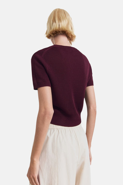 Bordeaux trui met ronde hals van MANGO, gedragen met een beige broek met hoge taille, achterzijde.