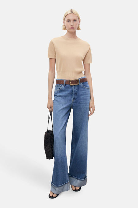 Beige ronde hals trui van MANGO, gedragen met een high-waisted jeans en een bruine riem.