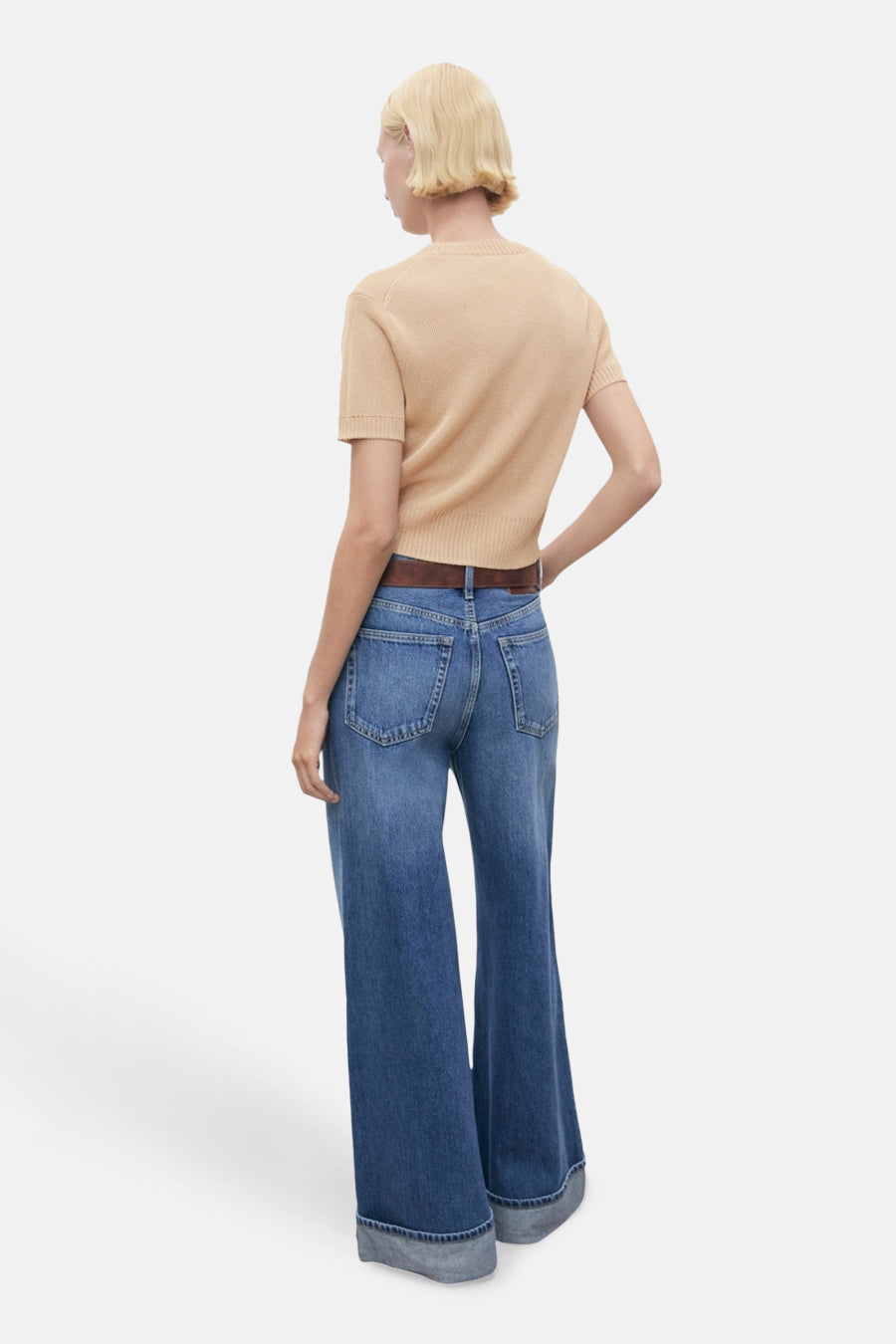 Beige ronde hals trui van MANGO, gedragen met een blauwe flared jeans en een bruine riem, achterzijde.