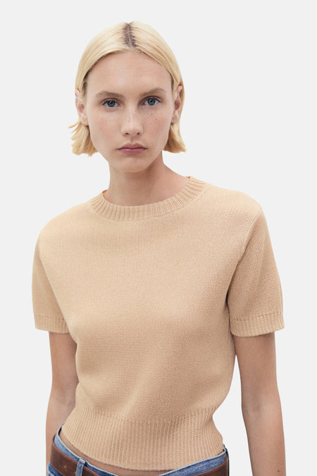 Beige trui met ronde hals van MANGO, in fijne breinaalden, gedragen met een spijkerbroek en een bruine riem.