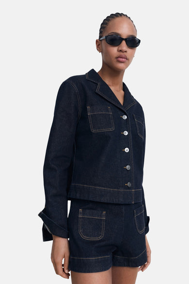 Bermuda en denim bleu foncé de MANGO, avec des poches plaquées et une coupe courte.