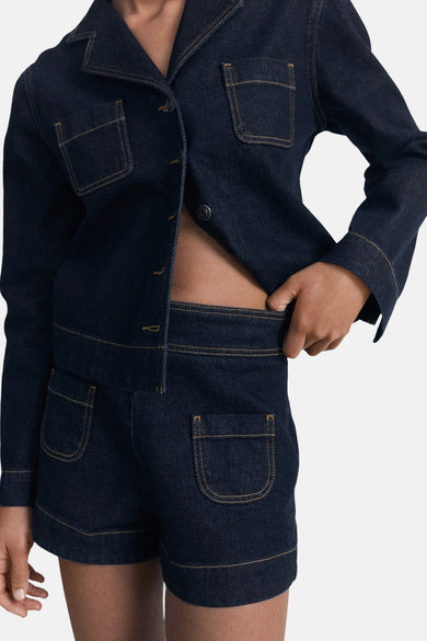 Bermuda en denim bleu foncé de MANGO, avec poches plaquées et coutures contrastantes.