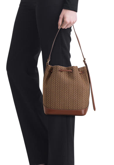 Bruine handtas van MANGO, met textuurpatroon, gedragen met een zwarte casual broek.