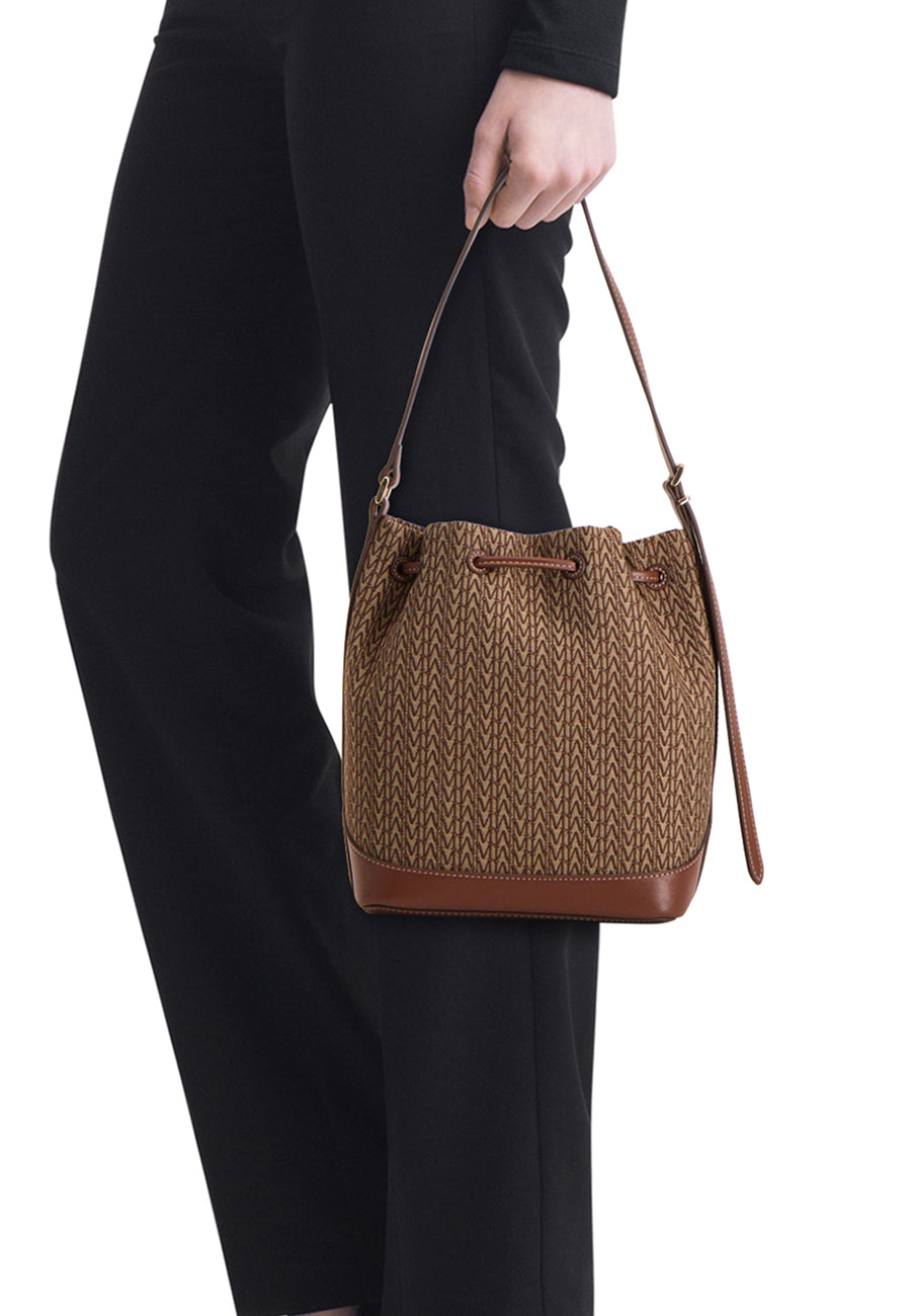Bruine handtas van MANGO, met textuurpatroon, gedragen met een zwarte casual broek.