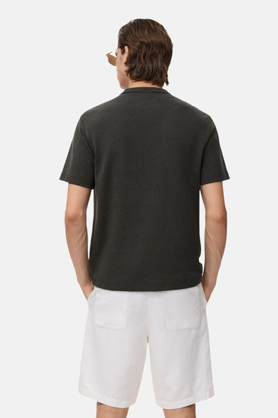 Zwart T-shirt met korte mouwen van MANGO, gedragen met een witte korte broek, achterzicht.