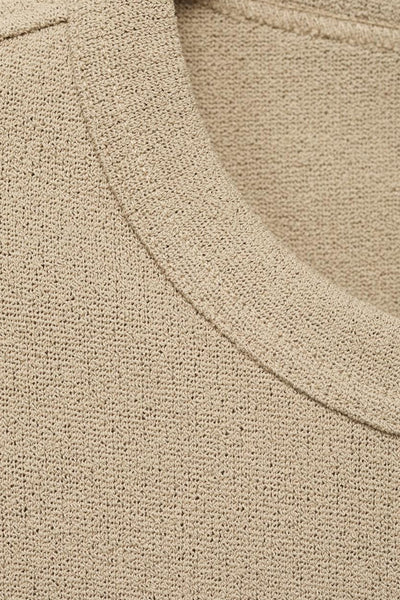 T-shirt beige à manches courtes de MANGO, avec une texture tricotée délicate et une encolure arrondie subtile.
