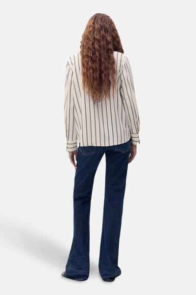 Chemise beige à rayures verticales, à manches longues par MANGO, vue de dos avec un jean bleu.