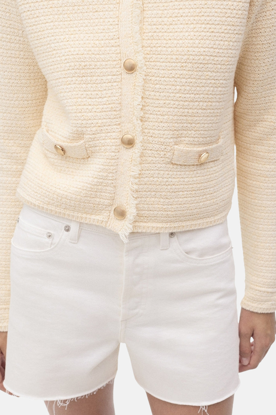 Cardigan écru de MANGO, en maille texturée avec boutons dorés et poches plaquées.
